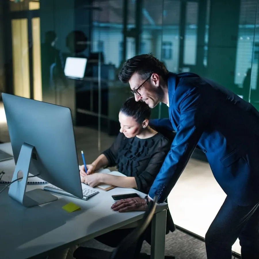 Technicians working through an IT issue at a workstation